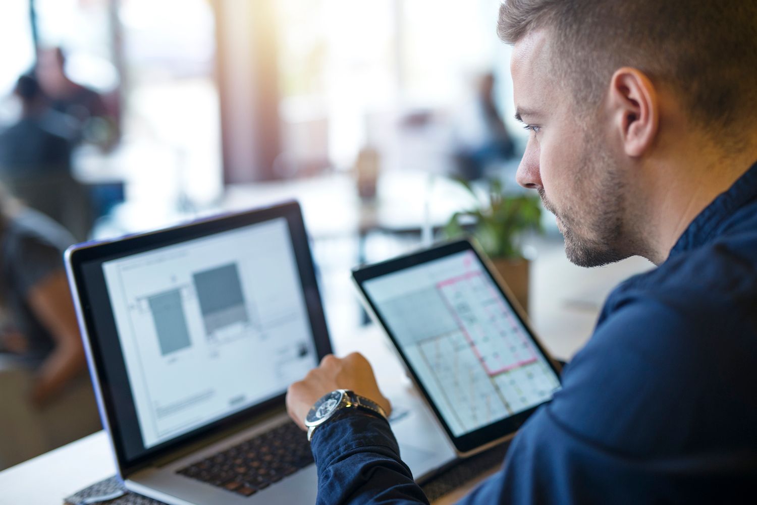 man using a laptop at a wooden desk